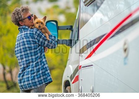 Retired Woman On The Road Trip With Her Small Breed Australian Silky Terrier Dog. Class C Motorhome.