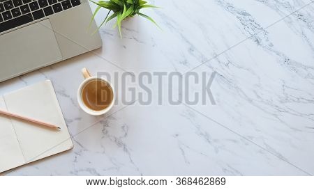 Close-up Image Part Of Laptop Including Coffee Cup, Pencil, Notebook And Potted Plant Putting On Mar