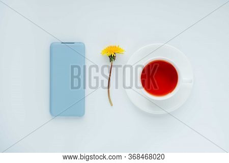 Morning Tea With Light Blue Mobile Phone, Bouquet Of Yellow Spring Dandelion Flowers. Beautifully St