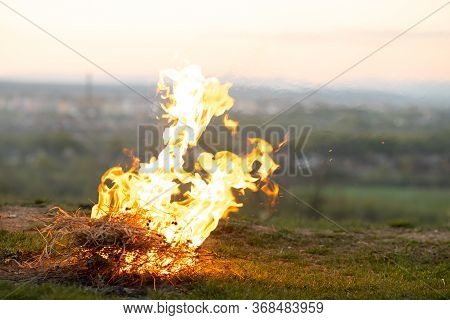 Big Bright Bonfire Bugning At Field In Evening.