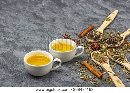 Assortment Of Different Grade Dry Tealeaf In Wooden Spoons And Two Cup Of Green Tea. Organic Herbal,