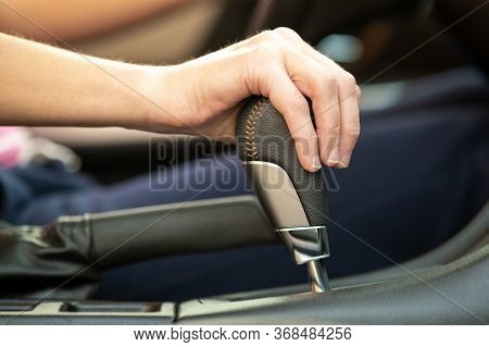 Close Up Of Woman Driver Holding Her Hand On Automatic Gear Shift Stick Driving As Car.