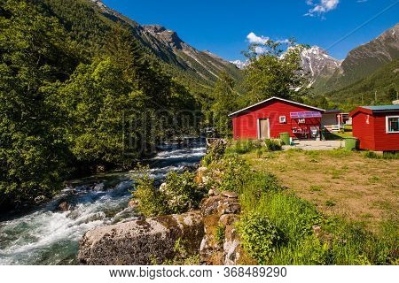 Picturesque Scene Of Urke Village And Hjorundfjorden Fjord, Norway. Drammatic Sky And Gloomy Mountai