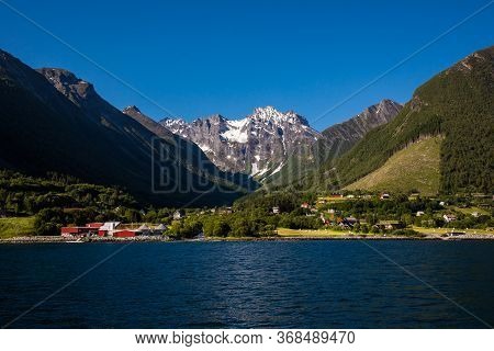 Picturesque Scene Of Urke Village And Hjorundfjorden Fjord, Norway. Drammatic Sky And Gloomy Mountai