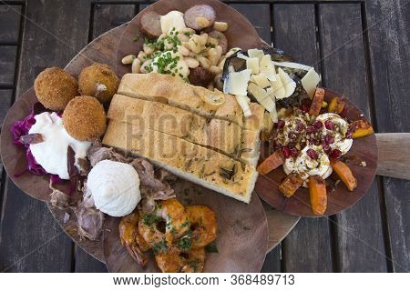 Gourmet Antipasto Board With A Selection Of Cured Meats, Local Cheeses, Pickled Vegetables, Herbed H