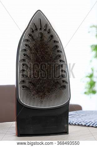 Iron With Damaged Soleplate Surface On Board, Indoors