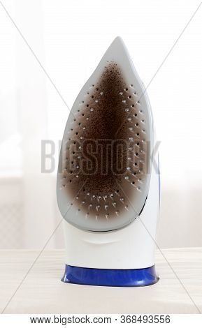 Iron With Damaged Soleplate Surface On Board, Indoors
