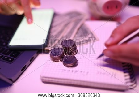 Close-up Of Person Accounting Money On Mobile Phone. Banknotes And Coins On Table. Detailed Shooting