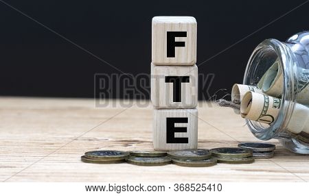 Fte On Cubes On The Background Of A Capacity With Money. Business And Finance.
