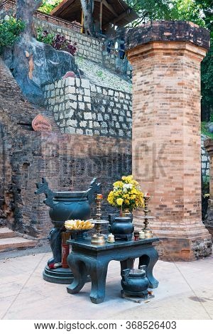 Buddhist Altar With Candles And Bananas And Flowers On Table In The Temple