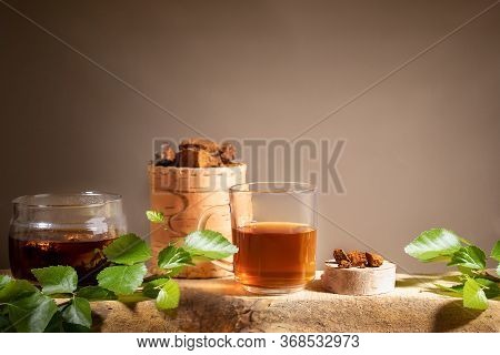 Healing Beverage From Birch Mushroom Chaga, Chaga Mushroom Pieces, Twigs On Wooden Plank On Beige Ba