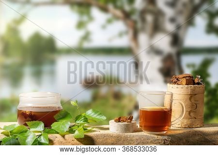 Healing Tea From Birch Mushroom Chaga And Chaga Mushroom Pieces On Blur Backdrop Of Birch Tree Near 