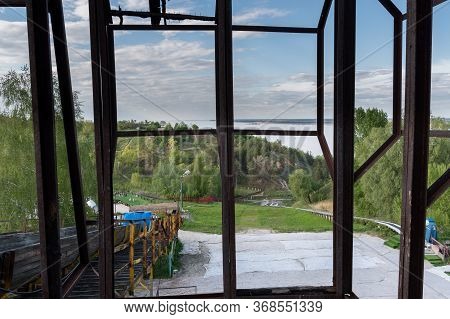 View From An Old Abandoned Cabin. Old Window With An Iron Frame. View Of The Street. Window Frame.