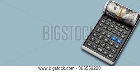 calculator and a roll of us dollarts on desk.
