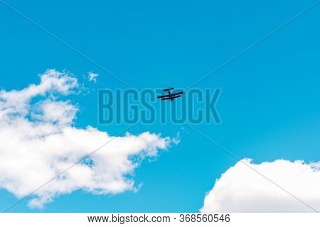 Flying Airplane In The Blue Sky With Clouds