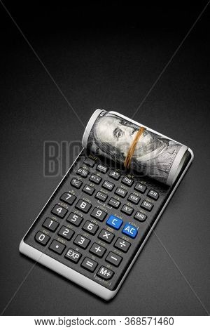calculator and a roll of us dollarts on desk.