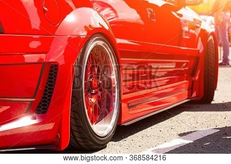 Red Sports Tuned Car Rear View Of The Wheel, Close-up . Fashion Car Day On The Road