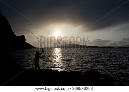 Sunsets Over Loch Na Keal On The Isle Of Mull As A Young Man Fishes For Mackerel In Color