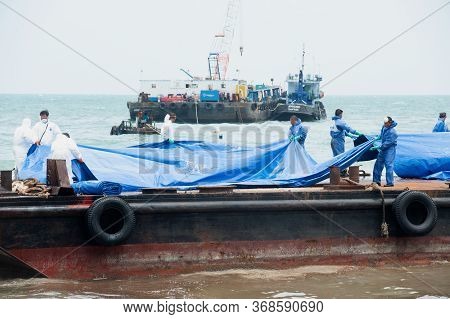 Rayong,thailand-february 8,2013 :   Workers And Volunteers Laying Large Plastic Sheets On A Crude Oi