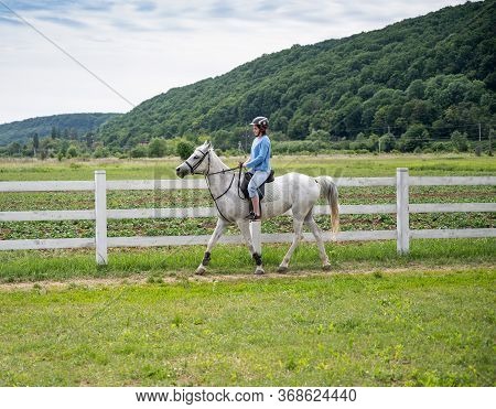 Dubky, Ukraine - May 23, 2020: Teen Girl In Helmet Learning Horseback Riding In Dubky
