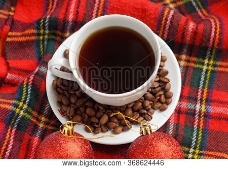 A Cup Of Coffee With Coffee Beans And Two Red Christmas Balls On Red Heckered Background.christmas H