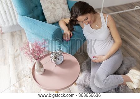 High Angle View Of A Beautiful Young Nine Months Pregnant Woman Relaxing At Home, Expecting Her Baby