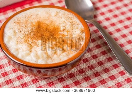 White Corn Cooked With Milk Known As Canjica, Canjicão Or Mungunza, In A Rustic Bowl On Wooden Table