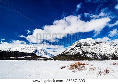 Snow Covered Rockies And Great Cloud Formations From Lower Lake. Peter Lougheed Provincial Park