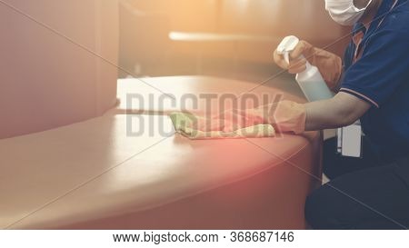 Woman Hand In Protective Orange Rubber Gloves Holding Green Microfiber Cleaning Cloth And Wiping Dus