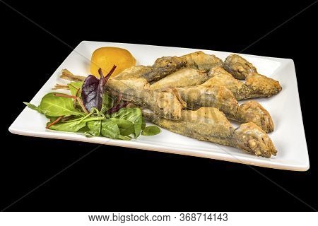 Gourmet Fried Trachurus With Lemon And Arugula On A Plate, Isolated On Black Background