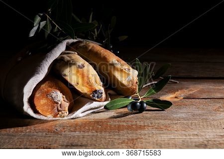 Traditional Italian Puccia Breads With Black Olives In A Cotton Bag, Made In Salento, Puglia On A Wo