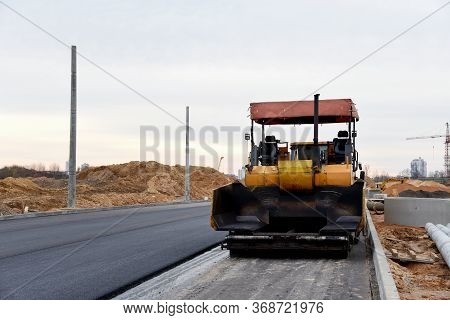 Asphalt Paver Machine During Road Work. Road Machinery At Construction Site For Paving Works. Screed