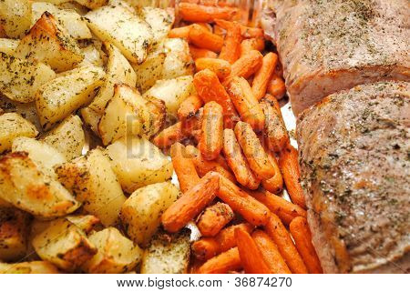 Cena de asado de cerdo con zanahorias y patatas