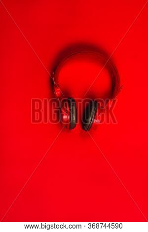 Red Headphones On Red Background. Music Concept