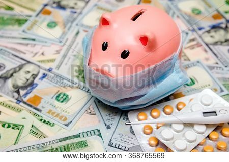 Piggy Bank In A Mask On A Background Of American Currency.the Concept Of Coronavrius Epidemic