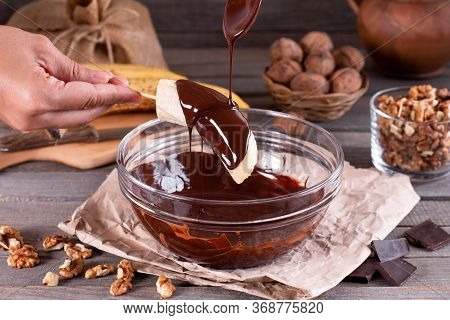 Woman Hands Pour Frozen Banana With Chocolate. Frozen Chocolate Covered Bananas On A Stick