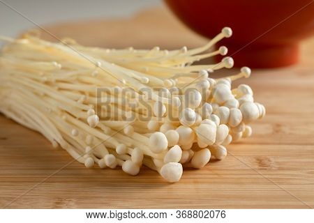 Cluster of fresh cultivated white enokii mushrooms close up 