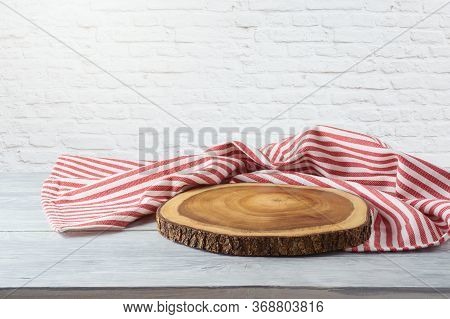 Empty Wooden Table With Tablecloth And Wooden Board Over White Brick Wall Background. Kitchen Mock U