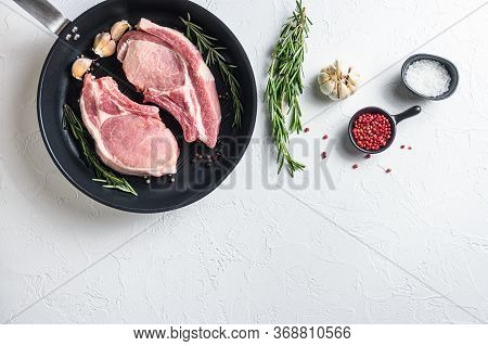 Fresh Pork Steak In A Frying Grill Pann On A White Stone Surface With Rosemary Garlic Peppercorns In