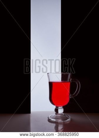 Red Glass With Red Liquid On A Black White Background. Stylish Photo