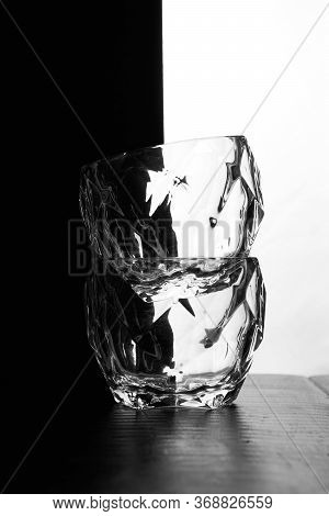 Glasses Of Whiskey Lie On Top Of Each Other. Theres A Bottle Of Whiskey. Black White Background. Sil