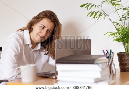 Woman Working On Laptop At Home Office While Drinling Coffee. Web Conection