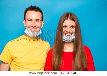 Happy Love Couple Remove Protective Mask Isolated On Blue Background. End Of Coronavirus Pandemic, Q