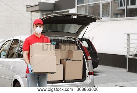 Delivery Of Big Parcels By Car With Courier At Home Concept. Curier In Medical Mask And Gloves Holds