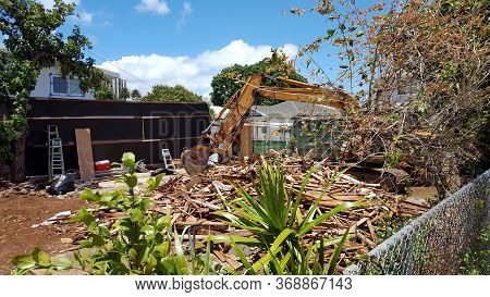 Honolulu - April 21, 2016: Construction Bulldozer Tears Down Home Of Lot In Kapahulu On Oahu, Hawaii