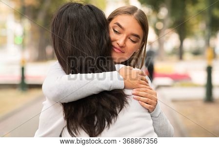 Lousy Friend. Sly Girl Embracing Desperate Girlfriend Pretending To Support Her Standing Outside.