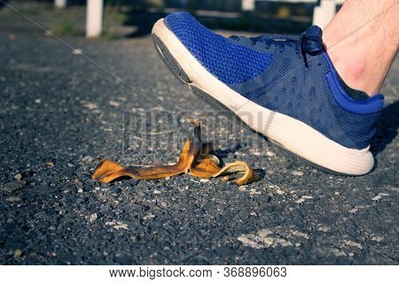 Caution, Risk Of Slipping.the Man Will Slip Over The Banana Peel In A Moment.the Men`s Shoe Almost T