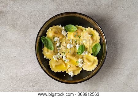 Girasoli Pasta With Soft Cheese, Olive Oil And Basil Leaves In Black Bowl Isolated On Gray Backgroun