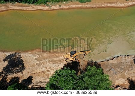 Environmental conservation issue. Machinery mining river, causing siltation and pollution 
