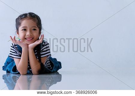 Cheerful Little Cuts Girl Smile Felling Relax While Lying Down On The Floor With Copy Space At Home.